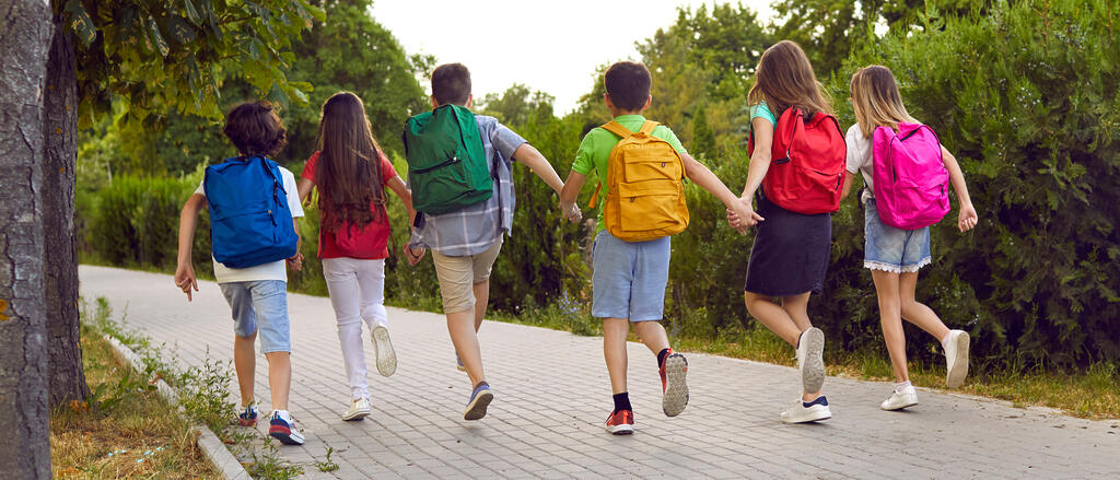 Kinder laufen Hand in Hand einen Weg entlang